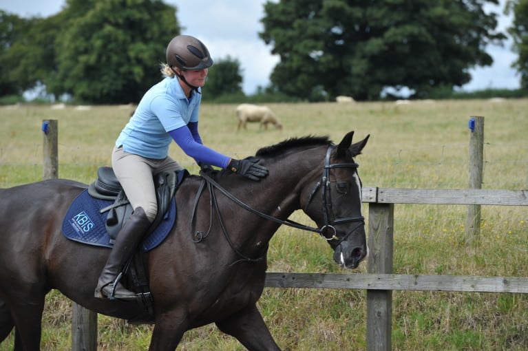 Rider patting their horse