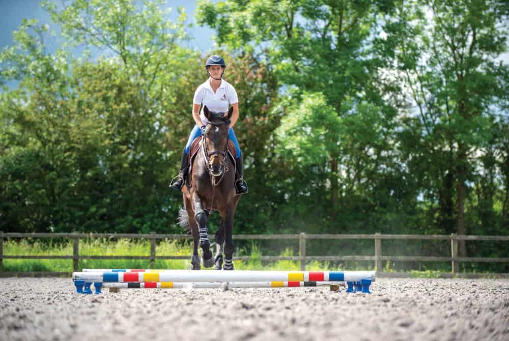Showjumper Anna Power riding a raised pole exercise